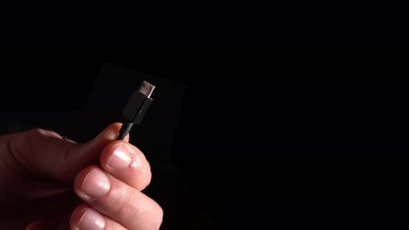 Mini Usb Connector In Hand On A Black Background