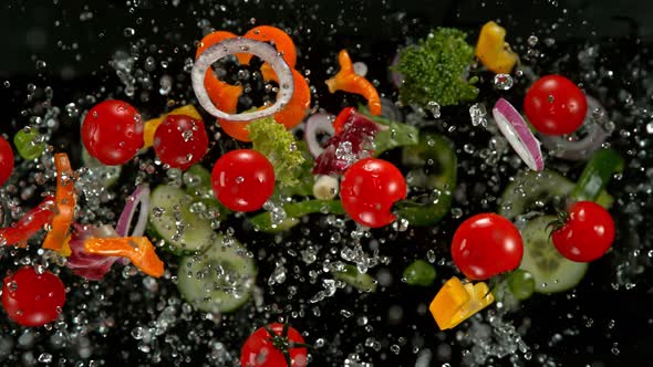 Super Slow Motion Shot of Flying Cuts of Colorful Vegetables and Water on Black at 1000Fps alt