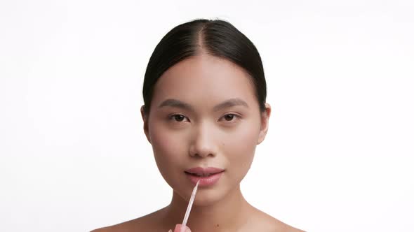 Korean Lady Applying Lipstick Smiling Making Makeup Over White Background alt
