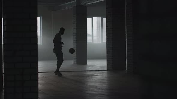 A Man Kick the Football Into a Wall in an Underground Parking Lot in the Sunlight in Slow Motion alt