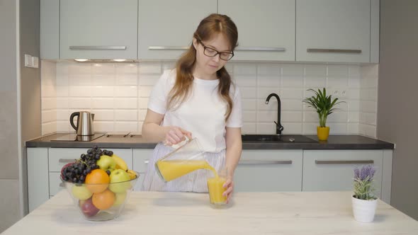 Adult Woman Pouring Juice in Kitchen