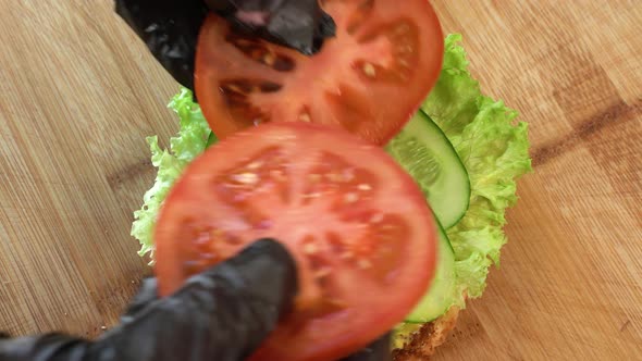Making Burger Closeup the Hand of a Chef in Black Gloves Prepares a Burger or Cheeseburger with a