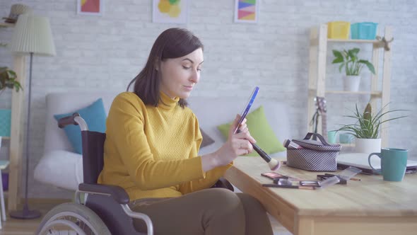 Portrait of a Young Disabled Woman in a Wheelchair Doing Makeup Going on a Date alt