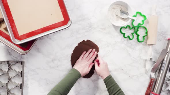 Flat lay. Step by step. Cutting out shapes with Christmas cookies cutter from gingerbread cookie dou alt