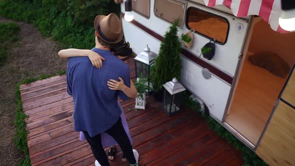 Young Caucasian Couple Dancing Slow Dance Embracing in Front the Trailer Wheels House alt