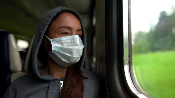 A Close-up Portrait of a Dark-haired, Middle-aged Woman Wearing a Medical Mask and a Hooded alt