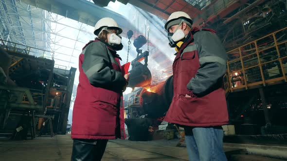 Metallurgical Factory with Two Industrial Workers Talking alt