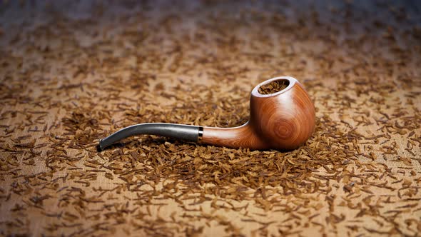 Old fashioned tobacco pipe.Elegant pipe on fabric in the middle of dried tobacco alt