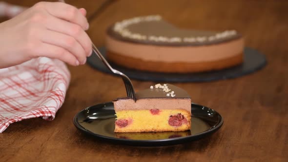 Eating piece of Chocolate Cherry Mousse Cake.	 alt