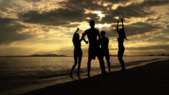 Groups of friends were dancing to celebrate a beach party in the evening when the sun was setting