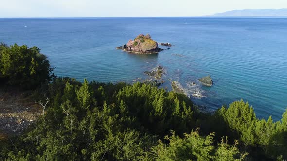 A Lonely Rocky Peak in the Open Sea Aerial Top View alt