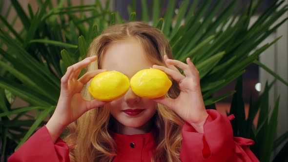 Cheerful Girl with Fashion Makeup Holding Lemons Front Eyes Like Glasses alt