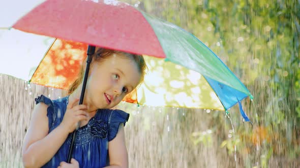 Funny Girl Hiding Under an Umbrella From the Rain. Warm Summer Rain alt