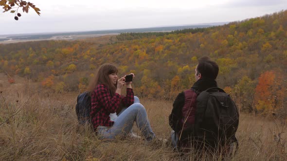 Travelers Are Photographed on a Smartphone Against Background of a Beautiful Landscape. Tourists alt