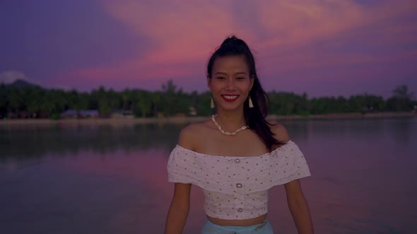 Cute Smiling Asian Woman Walking in the Sea at Beautiful Sunset Thailand
