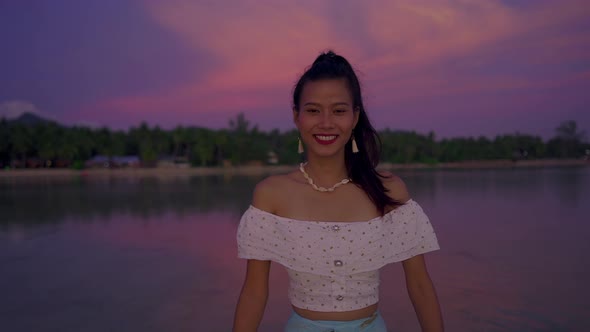 Cute Smiling Asian Woman Walking in the Sea at Beautiful Sunset Thailand alt