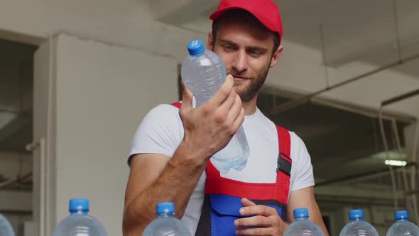 Young Man Worker of Water Factory Checking Quality and Making Inspection in Line Production