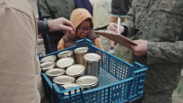 Giving Tinned Food to Refugees at Tent City alt