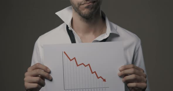 Businessman holding a negative financial chart
