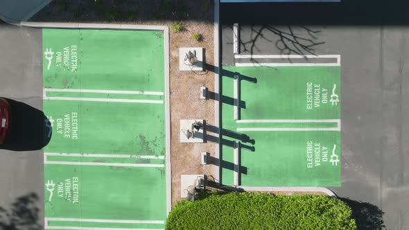 Vertical Shot of Modern Red Car Parking at Electric Vehicles Charging Station alt