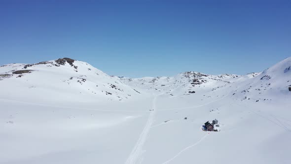 Ski trails with unrecognisable persons in Krossdalen snowy wilderness - Hardangervidda Norway revers alt
