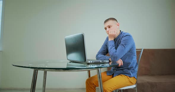 Bored Corporate Worker Holds Head on Hand and Nods at Laptop alt