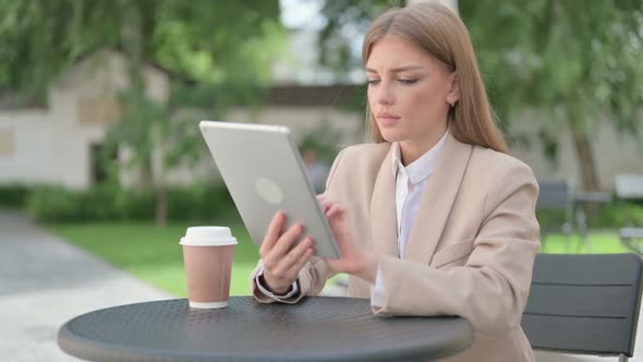 Successful Young Businesswoman Celebrating on Tablet in Outdoor Cafe alt