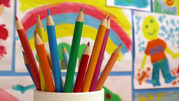 Color Pencils In Classroom With Paintings On Wall alt