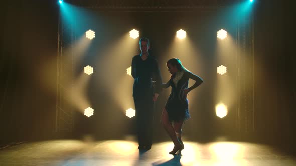 Young Couple Passionately Dancing Rumba and Moving in the Studio with Yellow Spotlights alt