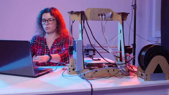 Concept of Modern Production Technologies. Young Woman Student Makes the Item on the 3D Printer alt