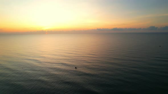 4K drone flying over the sea, sunset on the horizon alt