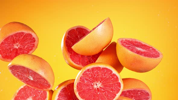 Super Slow Motion Shot of Flying Fresh Grapefruits and Water Side Splash at 1000 Fps alt
