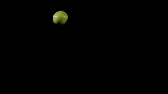 Close Up at Ripe Green Apple Flies Up and Spinning on a Black Background in Slow Motion Shot Vivid alt