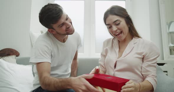 Young Man Surprise His Woman He Giving a Present alt