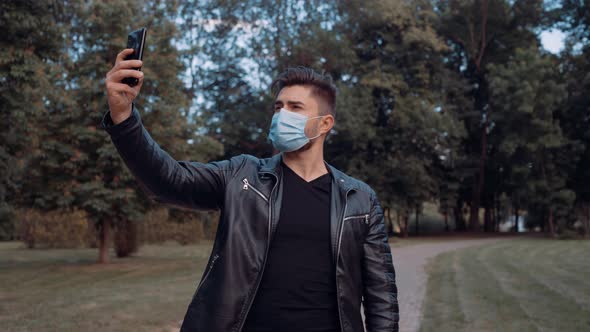 A Young Man Dressed in Black Clothes Takes a Selfie with His Mobile Phone, alt
