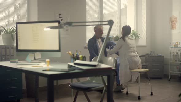 Medic Putting Cuff Measuring Pressure on Senior Patient Arm alt