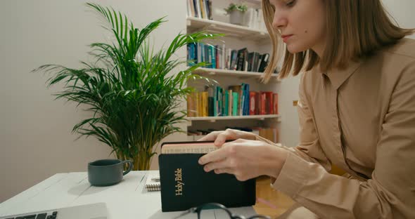 Young Christian Woman Studies Holy Bible Using Laptop Book Notebook at Home