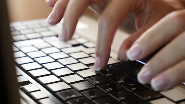 Office lady typing on dark laptop keyboard keys slow tilt 4K 2160p UltraHD footage - Business and in alt