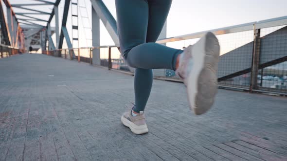Trained Muscular Legs of Young Lady Jogger Running By Bridge alt