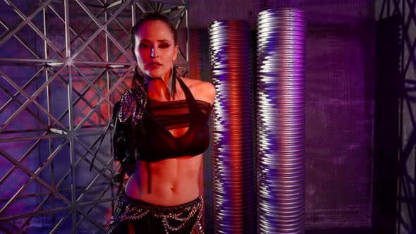 A Darkhaired Woman Dances a Modern Dance in a Darkened Studio She is Dressed in a Revealing Suit alt