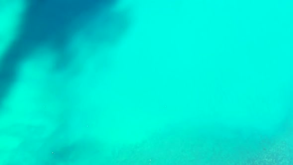 Aerial top down seascape of idyllic island beach voyage by aqua blue water and clean sandy backgroun alt