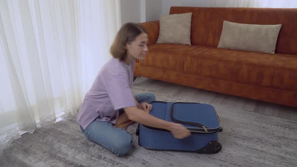 A Woman Packed a Suitcase with Clothes and Closed It Preparing for a Trip on Vacation