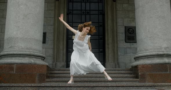Young Dancer in White Dress Dances on the Stairs of the Theatre in Slow Motion Balerina Does Dance alt
