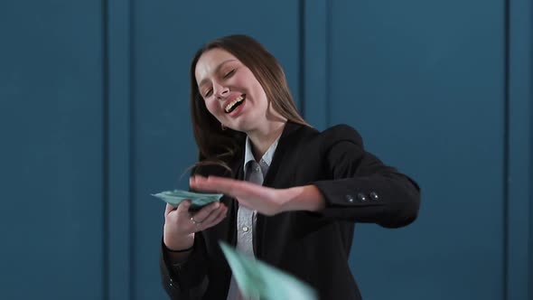 Young Happy Businesswoman Dancing and Throwing Money. Slow Motion. Successful Business or Winning alt