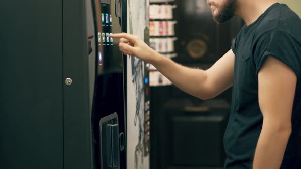 Young Man Buying Coffee Vending Machine alt
