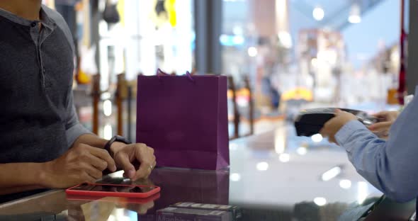 Young muslim man use smartwatch paying over contactless transactiona at cashier counter 