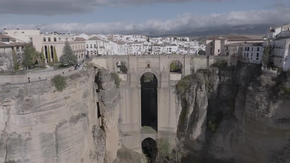 Aerial ascends over Ronda Spain and medieval arch bridge over gorge alt