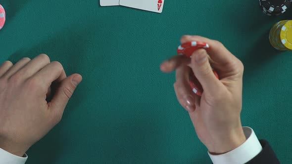 Casino Player Holding Chips in Hands and Analyzing Next Step, Business Strategy