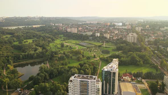 Aerial drone view of Dendrarium Park with lush greenery and lake. Panorama view of multiple building alt