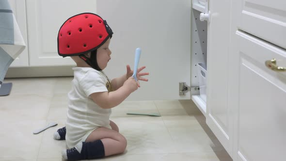 Active Child Playing in the Kitchen Curious Toddler Exploring Kitchen Cupboard Cute Baby Boy Crawler alt